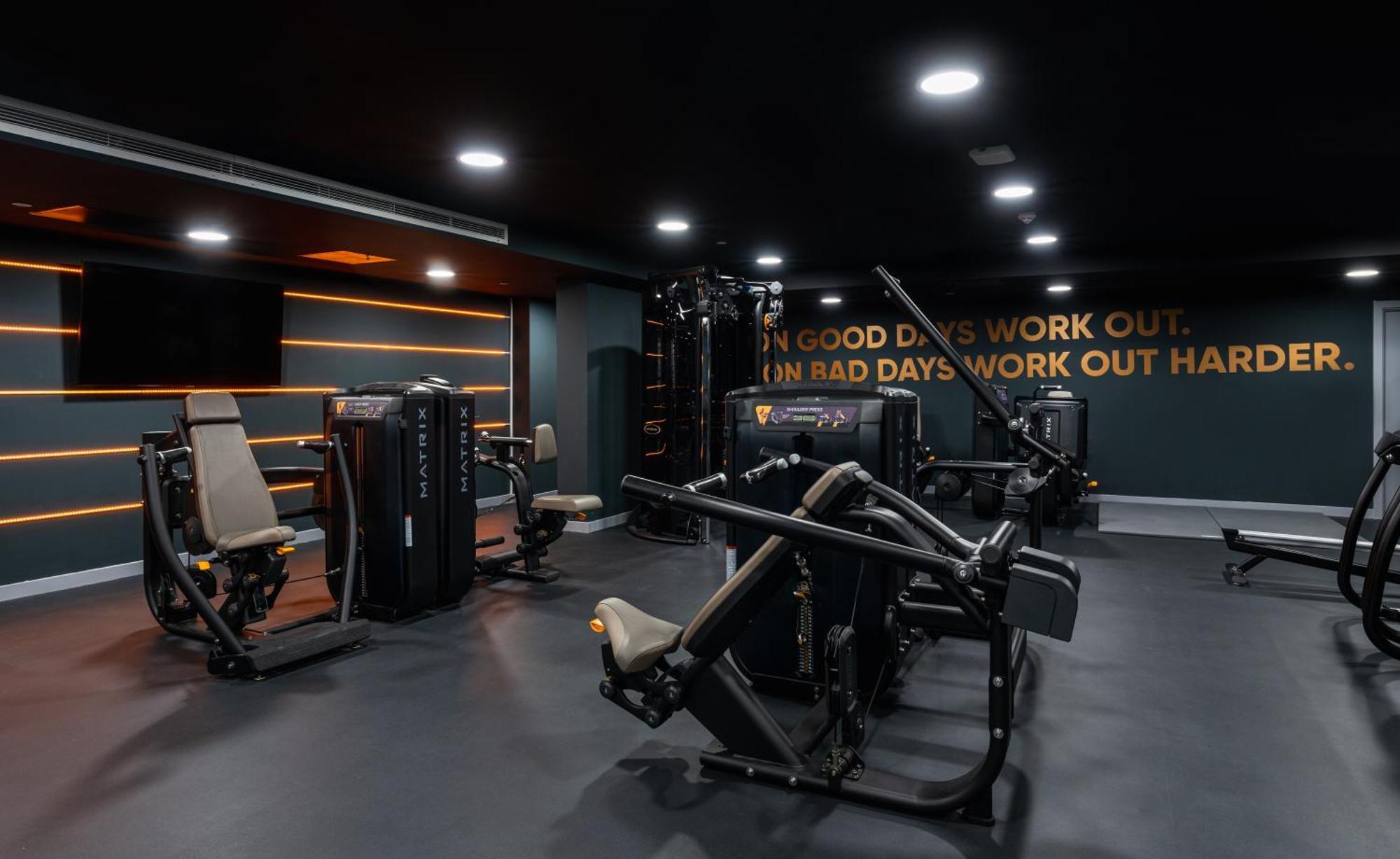 Citysuites 2 Aparthotel Salford  Exterior foto The photo shows a modern gym interior. The gym features various exercise machines, including weight training equipment. The flooring is dark, and the walls are adorned with motivational text that reads, "ON GOOD DAYS WORK OUT. ON BAD DAYS WORK OUT HA